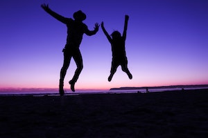 two people jumping with Sunday behind
